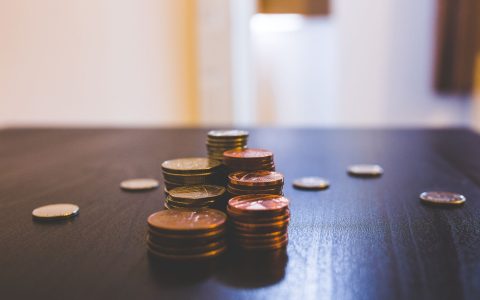 pile of brown coins on brown wooden table top