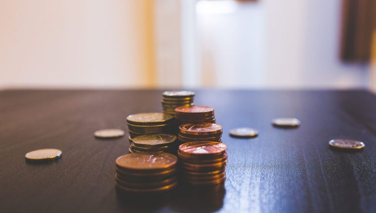 pile of brown coins on brown wooden table top