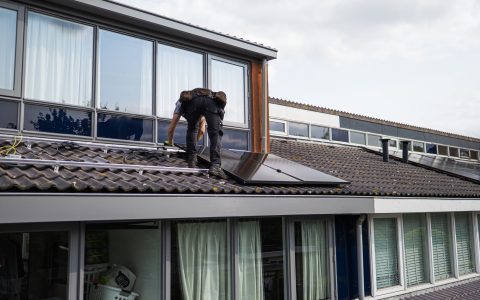 technician installing solar panels on rooftop