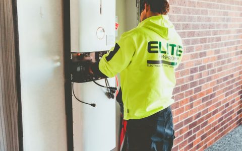 electrician installing solar inverter indoors