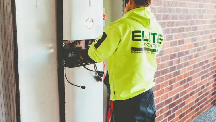 electrician installing solar inverter indoors