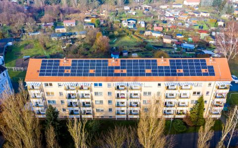 drone shot of a building with solar panels on roof