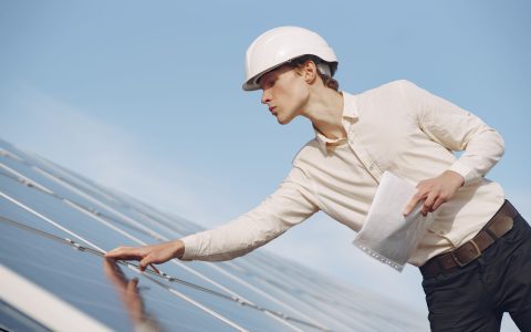 solar technician inspecting solar panel