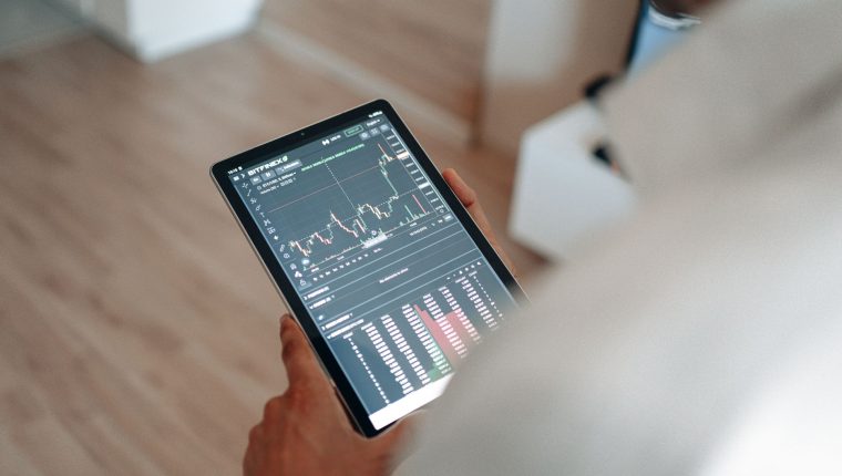 hand holding black tablet with graph on screen