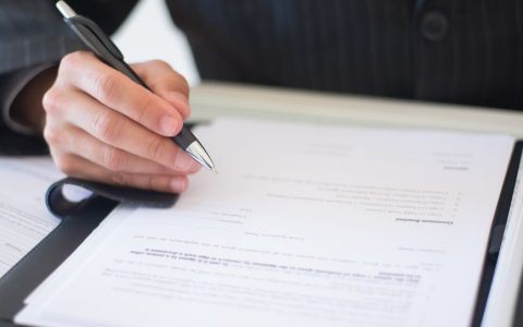 a person s hand holding a black and silver pen