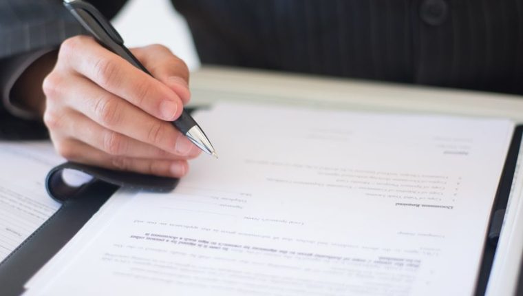 a person s hand holding a black and silver pen