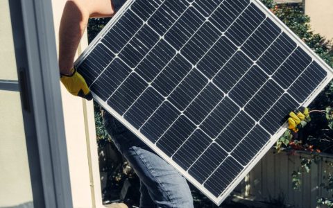 a person carrying a solar panel