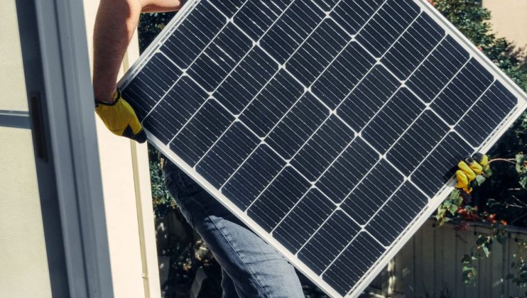 a person carrying a solar panel