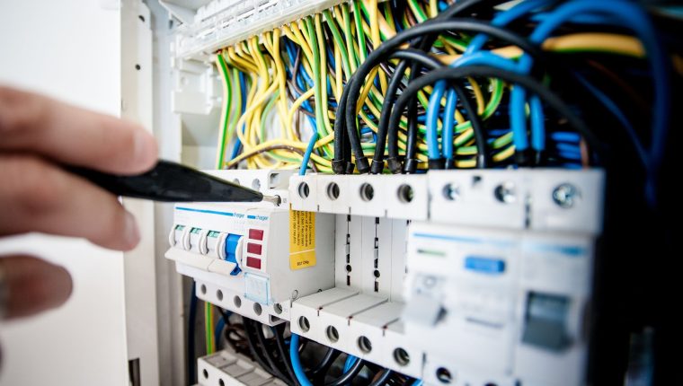 electrician fixing an opened switchboard