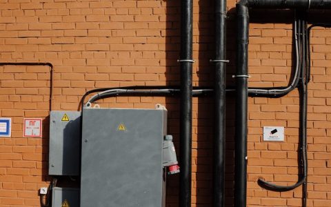 gray and black metal frame and pipes on brown brick wall