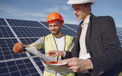 two electricians standing near the solar panels