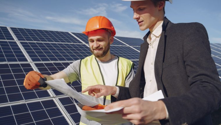 two electricians standing near the solar panels