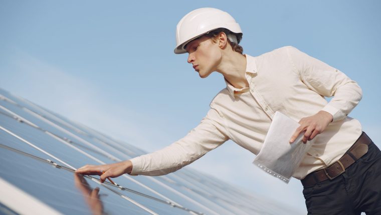 solar technician inspecting solar panel