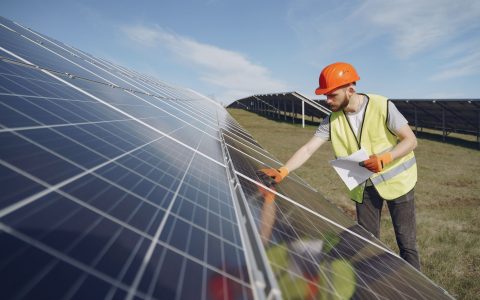 solar technician inspecting solar panel