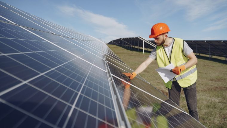 solar technician inspecting solar panel