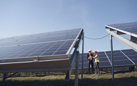 two electricians standing near the solar panels