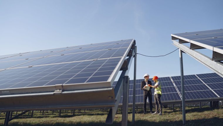 two electricians standing near the solar panels