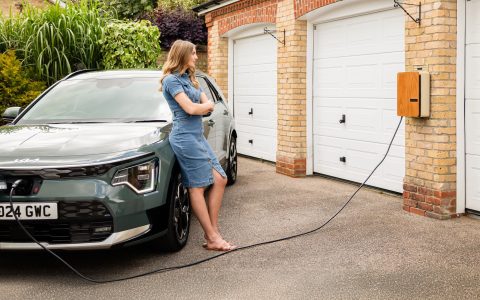 young lady with an andersen home electric vehicle charge point and all electric kia niro