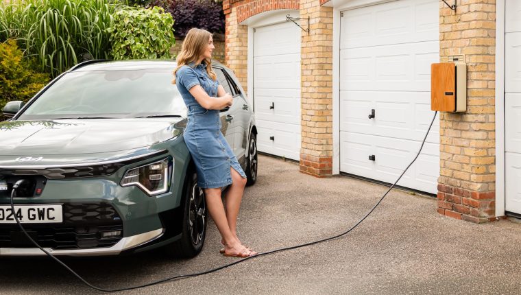 young lady with an andersen home electric vehicle charge point and all electric kia niro