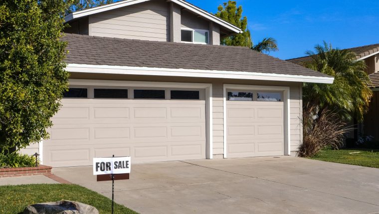 for sale sign in front of a house