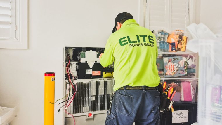 technician installing home battery system indoors